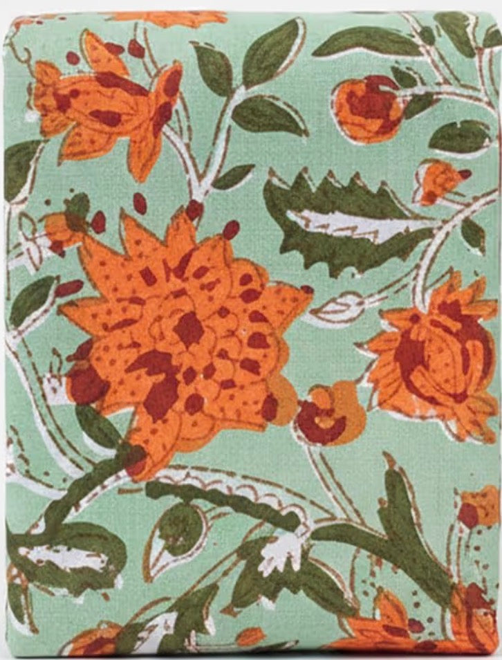 Floral patterned fabric with orange flowers on a green background