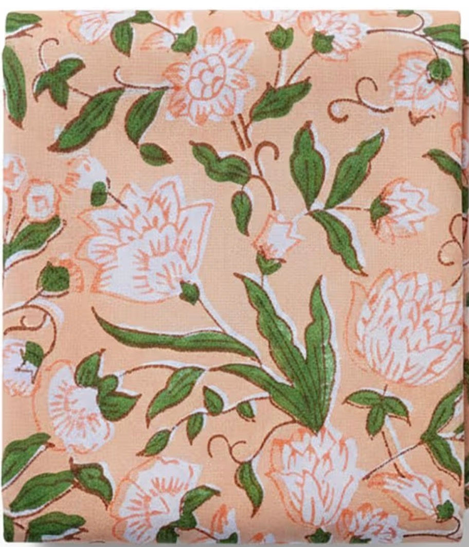 Floral patterned fabric with green leaves and white flowers on a beige background
