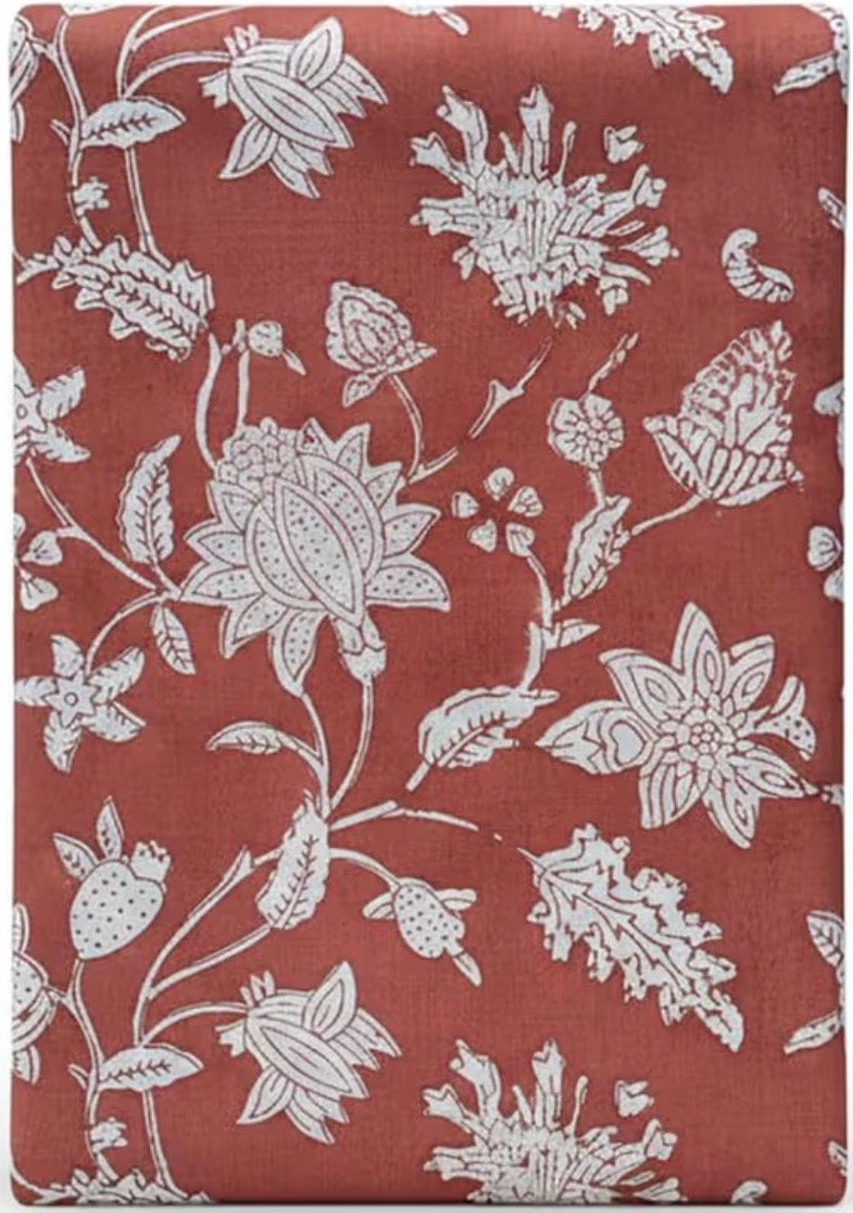 Floral patterned fabric with white flowers on a red-brown background