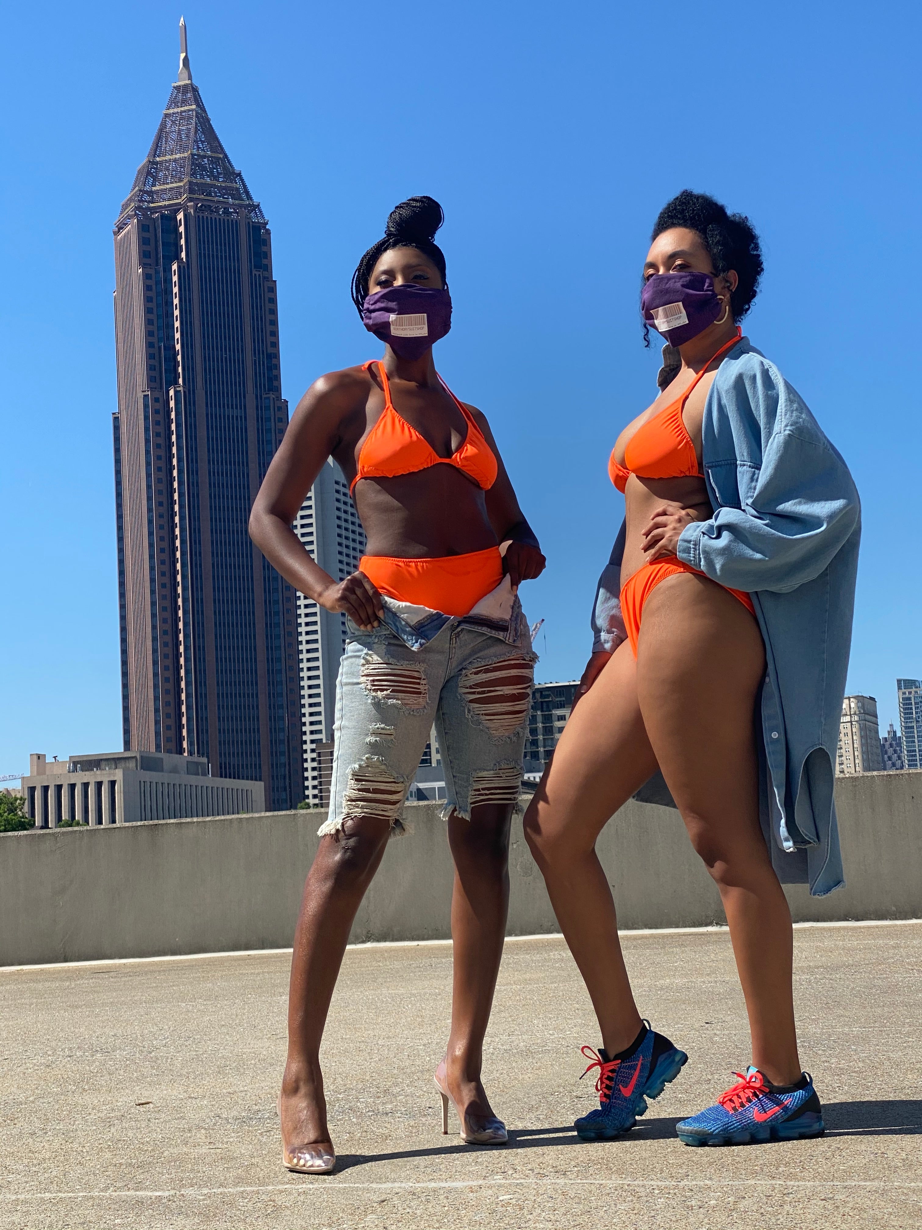 Two people running on a sidewalk with a city skyline in the background