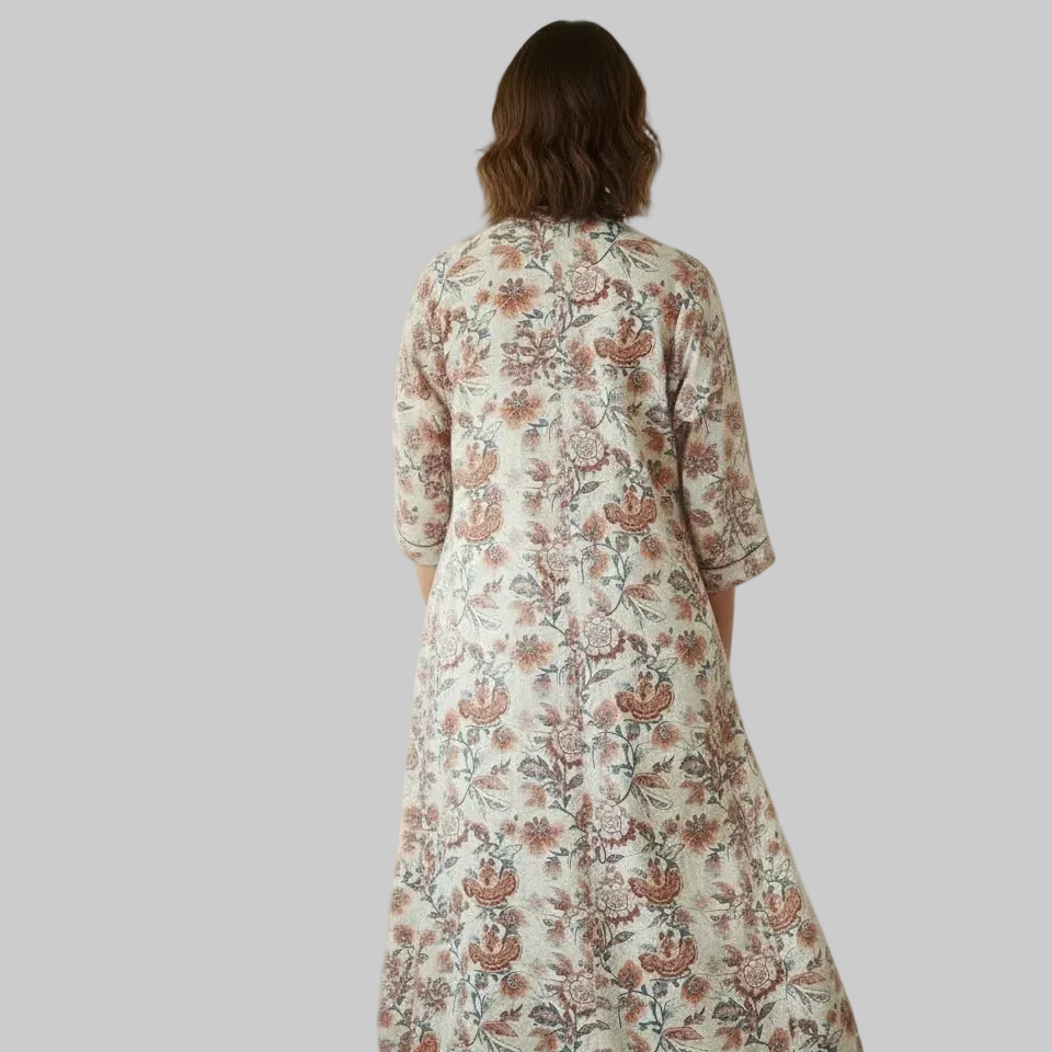 Woman in a kimono dress standing in a bright living room.