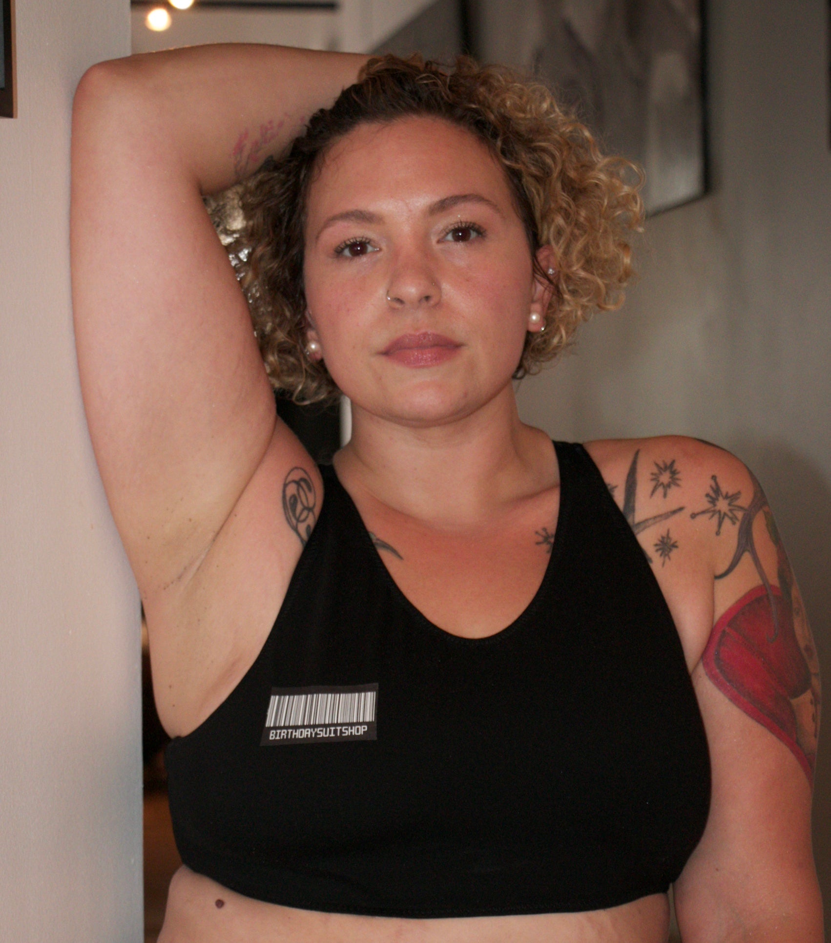 Woman wearing a black sports bra with a visible brand logo indoors.