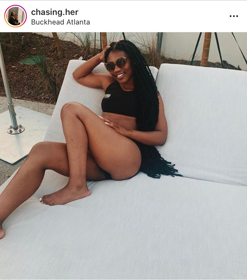 Woman in a black bikini sitting on a white outdoor sofa with a blurred background
